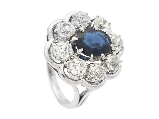 RING, 18K vitguld, blå safir ca 1,35 ct, 8 gammalslipade diamanter ca 1,75 ctv, ca TCa/SI-P, stl 16 mm, vikt 7,1 g, diamanter med mindre skador och nagg.