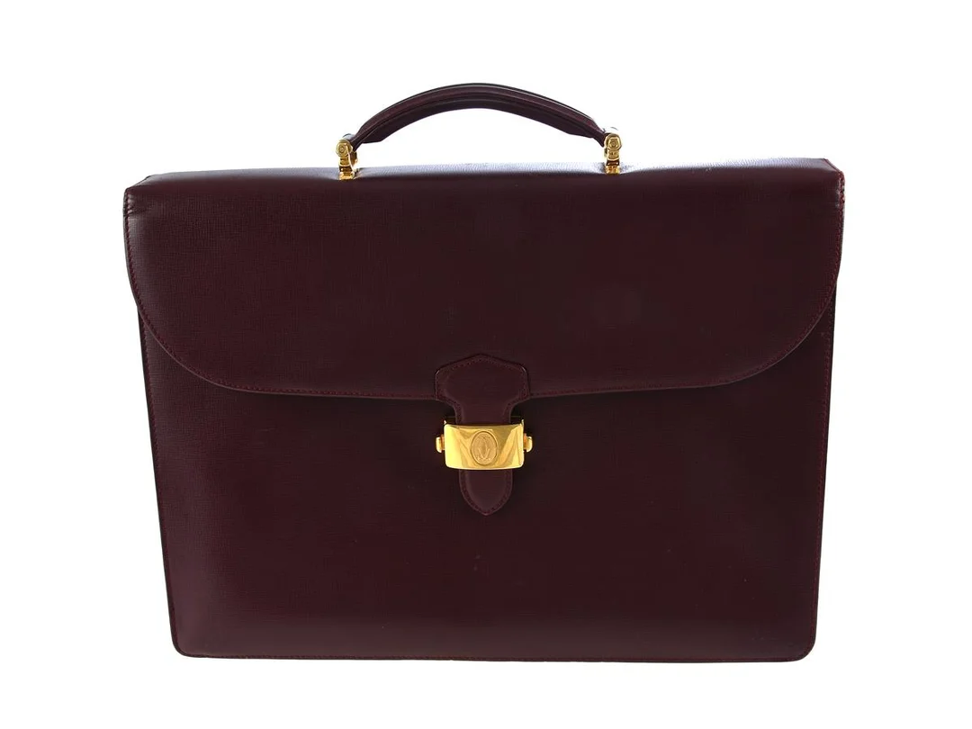 PORTFÖLJ, CARTIER, vinrött läder, guldfärgade beslag, 40x29x8 cm. — Accessoarer/Väskor — Kaplans