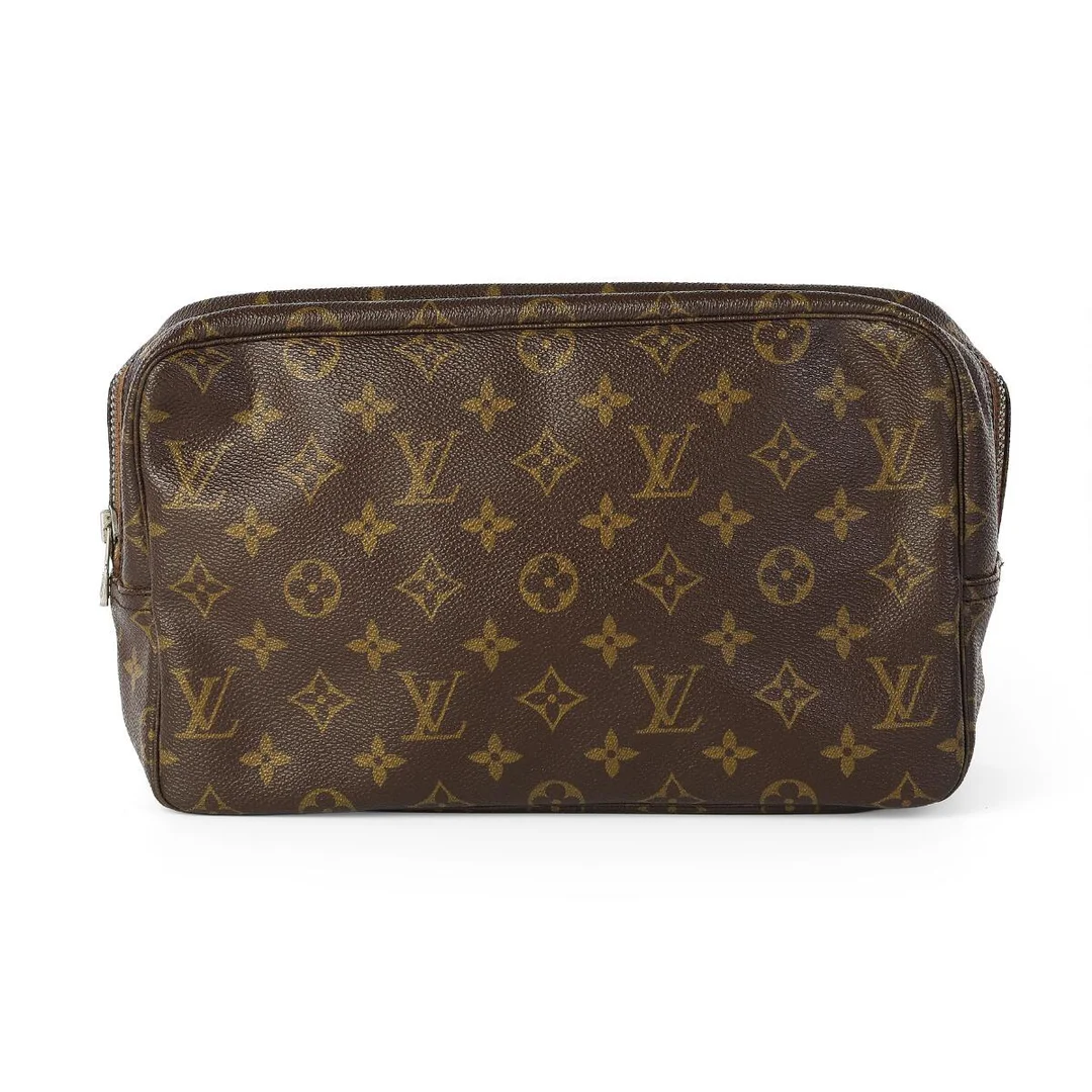 A “Trousse Toilette 28” of brown monogram canvas with silver tone hardware, one zipped compartment with an interior pocket, straps and beige lining. H. 18 x W. 28 x D. 8 cm. — Designer Handbags & Fashion/Designer Handbags — Bruun Rasmussen