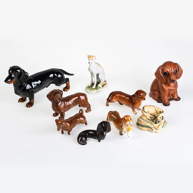 A GOEBEL POTTERY DACHSHUND AND OTHER DOG FIGURINES.