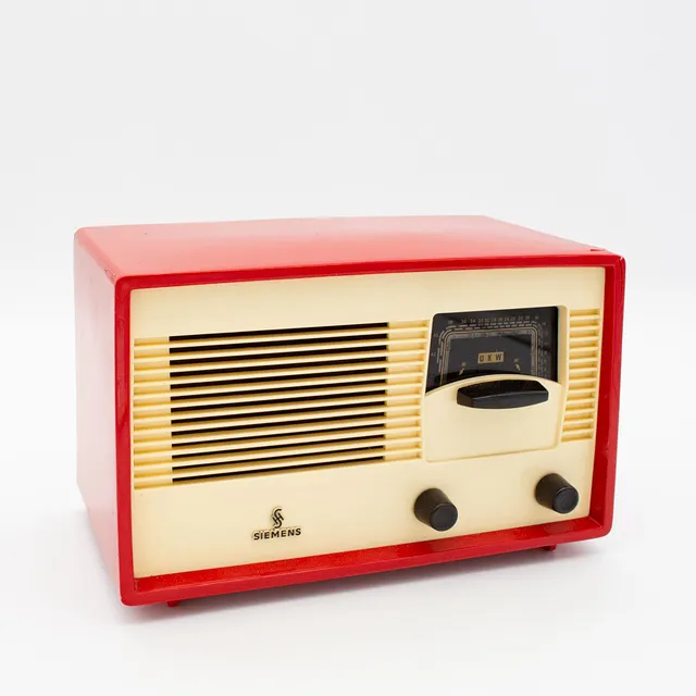 HISTORISCHES RÖHREN-TISCHRADIO VON SIEMENS, MODELL SIEMENS SUPER A 60, 1950ER JAHRE, GEHÄUSE ROTER KUNSTSTOFF MIT EINER ELFENBEINFARBENEN FRONTBLENDE, EINEM LAUTSPRECHERGITTER UND SCHWARZEN DREHKNÖPFEN.