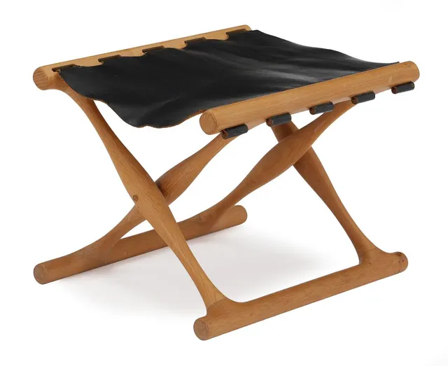 “Guldhøj Stool”. Oak folding stool. Seat upholstered with black leather. Model PH 41. Manufactured by Poul Hundevad, Vamdrup. H. 31 cm.