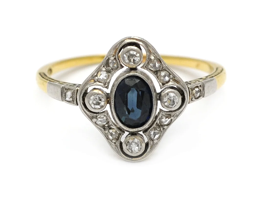 RING, 18K guld/platina, ovalt fasetterad blå safir, 14 åttkant- och rosenslipade diamanter ca 0,12 ctv, ca W/VS, stl 17 mm, vikt 2,3 g. — Smycken/Ring — Kaplans