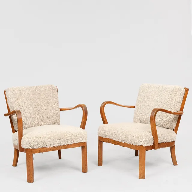 DANSK SNEDKERMESTER. Et par lænestole med stel af eg, sæde og ryghynde nybetrukket med lammeskind, 1930/40'erne, (2).