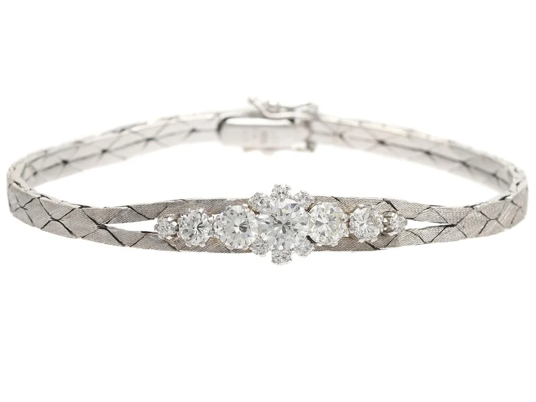 ARMBAND, 18K vitg., 13 briljanter ca 2,25 ctv ca TW-W/VVS-VS, längd 16,5 cm, vikt 18,1 g. ARMBAND, 18K vitguld, 13 briljantslipade diamanter ca 2,25 ctv ca TW-TCr/VVS-SI, längd 16,5 cm, vikt 18,1 g, enligt gravyr så finns det en sten 0,74 ct TW/SI, två stenar 0,42 ct styck TCr/VVS samt 2 stenar 0,24 ct styck TCr/VS. — Smycken/Armband — Kaplans