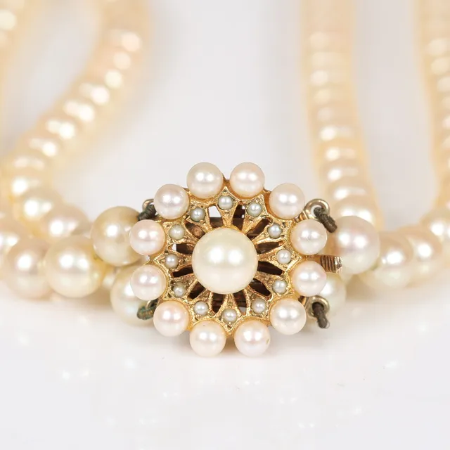 A 9CT GOLD CLASPED CULTURED PEARL NECKLACE.