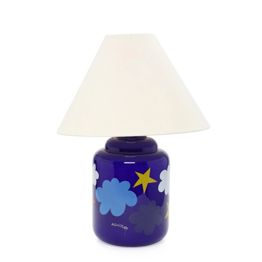 “Arnoldi”. A blue glass table lamp with polychrome decor in the shape of clouds and stars. Marked Arnoldi. Manufactured by Holmegaard. H. 55 cm. incl. shade. — Modern Lighting — Bruun Rasmussen