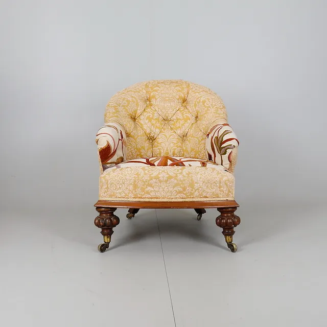 A VICTORIAN ROSEWOOD AND BUTTON UPHOLSTERED LOW CHAIR.
