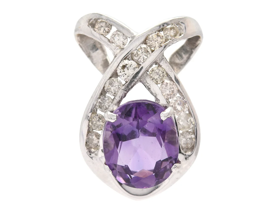HÄNGE, 18K vitguld, ovalslipad ametist ca 2,4 ct, 15 briljantslipade diamanter ca 0,45 ctv, ca Cape/SI-P, höjd 2 cm, vikt 3,6 g, en diamant är skadad. — Smycken/Hänge — Kaplans