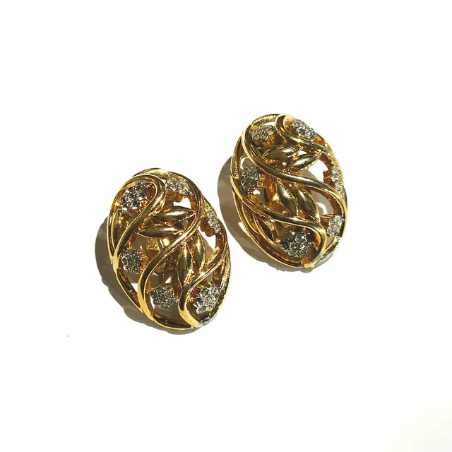 NINA RICCI. Grandes pendientes ovalados en metal dorado y circonitas formando flores.