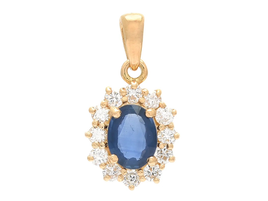 CARMOSÈHÄNGE, 18K guld, ovalslipad blå safir ca 1,00 ct, 12 briljantslipade diamanter ca 0,61 ctv, ca W(H)/VS, stl 2,1 x 1,1 cm, vikt 2,4 g. — Smycken/Hänge — Kaplans