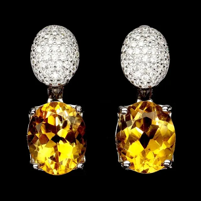 Earrings in sterling silver adorned with two larger oval-cut citrines and zircons.