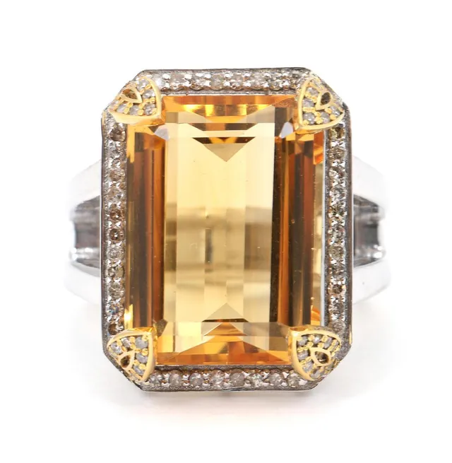 A citrine and diamond ring set with an emerald-cut citrine of app. 16.55 ct encircled by numerous single-cut diamonds weighing a total of app. 0.50mct, mounted in silver and 14k gold. Weight app. 12 g. W. 21 mm. Size 56.
