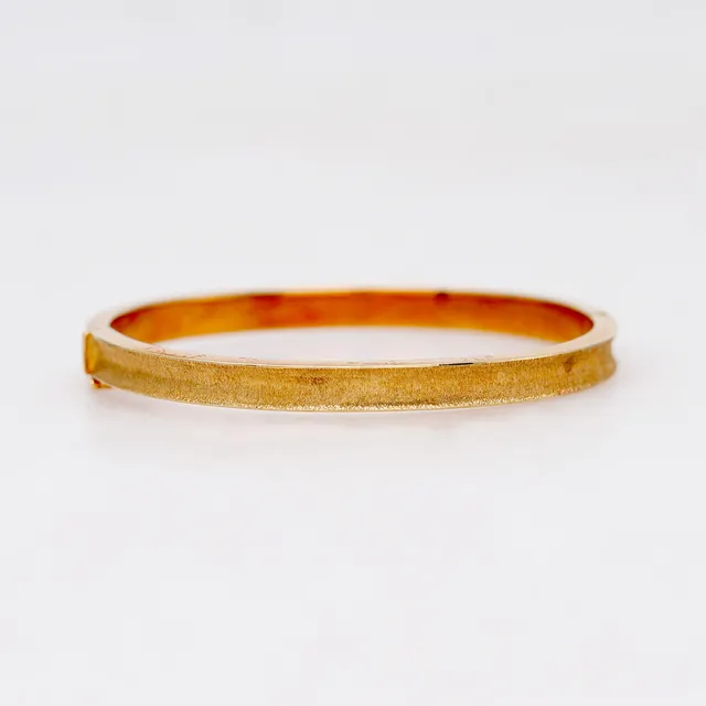 Textured gold bangle bracelet.