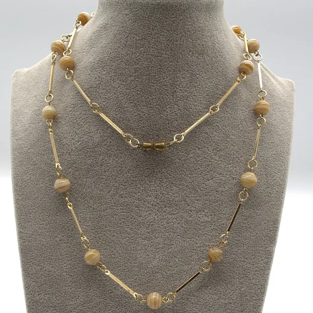 MURANO GLAS COLLIER,MIT CREMEFARBENEN, BERNSTEINFARBIGEN GLAS PERLEN UND VERGOLDETEN METALL VERZIERTEN ZWISCHENELEMENTEN UM CA. 1950 CA. 60 CM.
