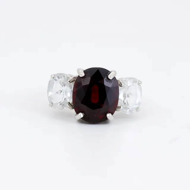 9CT WHITE GOLD GARNET AND WHITE STONES SET RING.