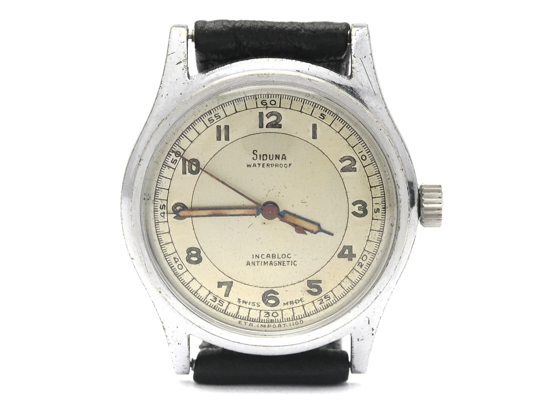 SIDUNA, herrur, 34 mm, Cal 1100, Boett nr. 17544, vitmetall, manuell, plexiglas, skadad urtavla, skadad boett, läderband, ca 1950. — Klockor/Övriga klockor — Kaplans