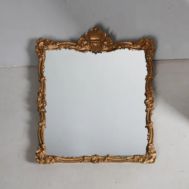A GILT GESSO WALL MIRROR.