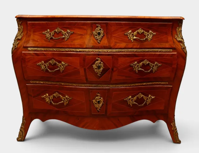 Cómoda de estilo Luis XV en caoba, con tiradores, bocallaves y aplicaciones en bronce dorado.