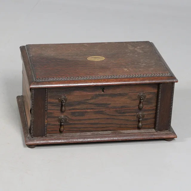 A TABLE TOP CANTEEN OF PLATED CUTLERY IN OAK CABINET.