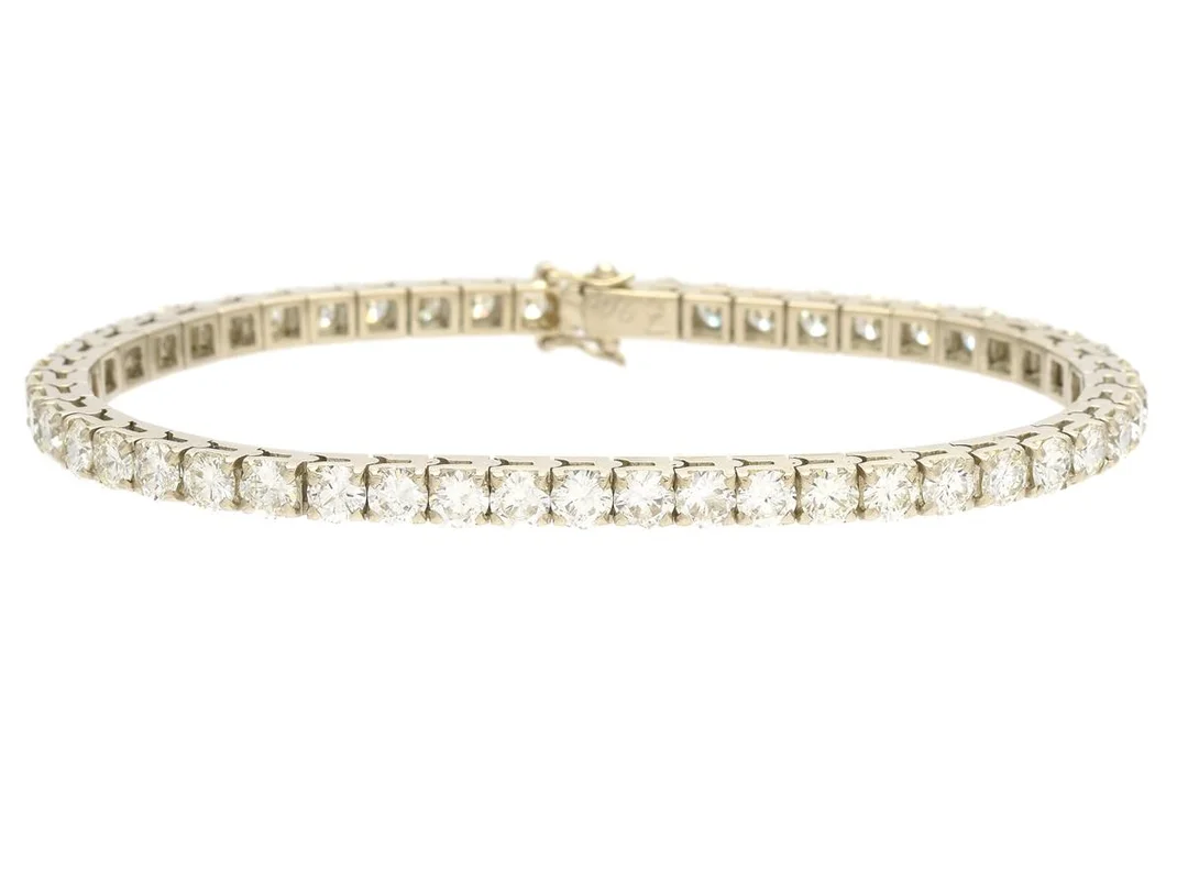 TENNISARMBAND, 18K vitguld, 49 briljantslipade diamanter ca 7,90 ctv, ca W-TCa/VVS-VS, längd 18 cm, vikt 16,9 g,några diamanter med skador och nagg. — Smycken/Armband — Kaplans