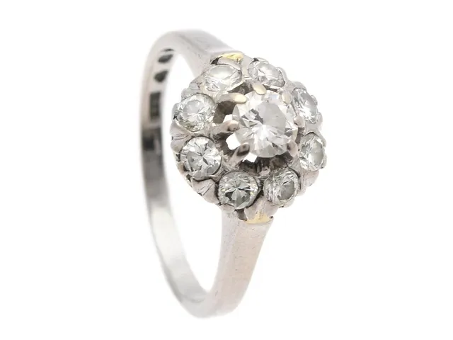 RING, 18K vitguld, 9 briljantslipade diamanter enligt gravyr 0,92 ctv ca TW/VS, stl 16,5 mm, vikt 4,1 g, mittstenen har ett större nagg, skadad fattning.