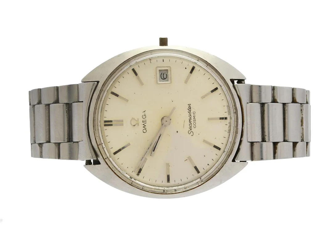 OMEGA, Seamaster Cosmic (-T Swiss Made T-), Cal 613, Serie nr. 26727535, Ref nr. ST 136.017, Boett nr. 136.017 SP, herrur, 35 mm, stål, manuell, plexiglas, datum, skadad urtavla, defekt (går ej, servicebehov), saknar krona/ställaxel, ca 1968, metallänk ej original. — Klockor/Omega — Kaplans