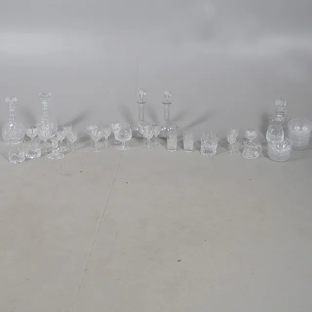 A COLLECTION OF CUT GLASS DECANTERS AND GLASSES.