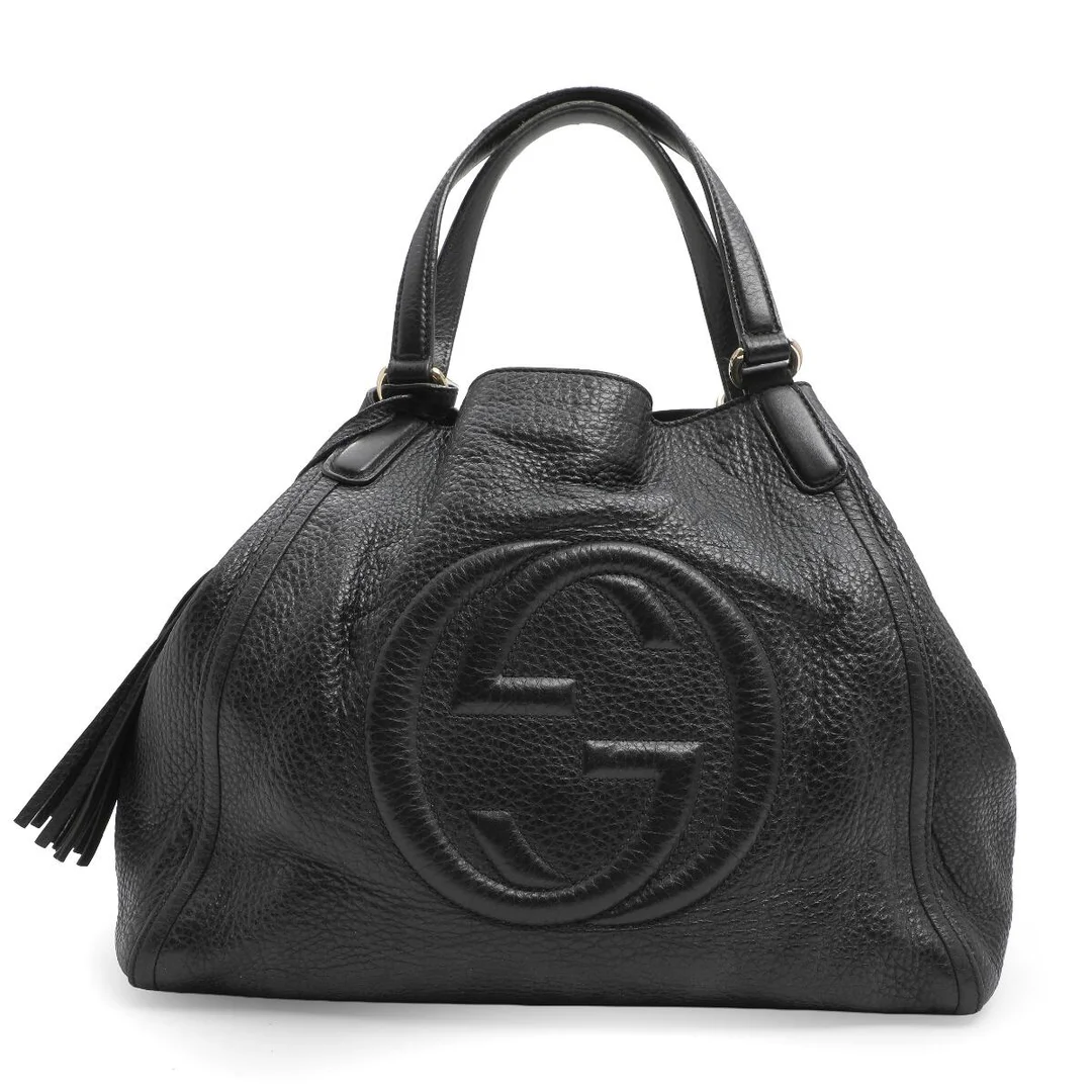A black leather “Soho” tote bag with gilt hardware, two handles, one compartment with hook fastening, three interior pockets, one of which zipped, and beige fabric lining. H. 28 x L. 35 x W. 16 cm. — Designer Handbags & Fashion — Bruun Rasmussen