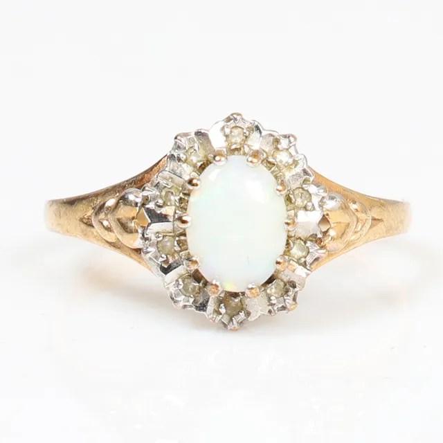 A 9 CARAT GOLD AND OPAL RING.