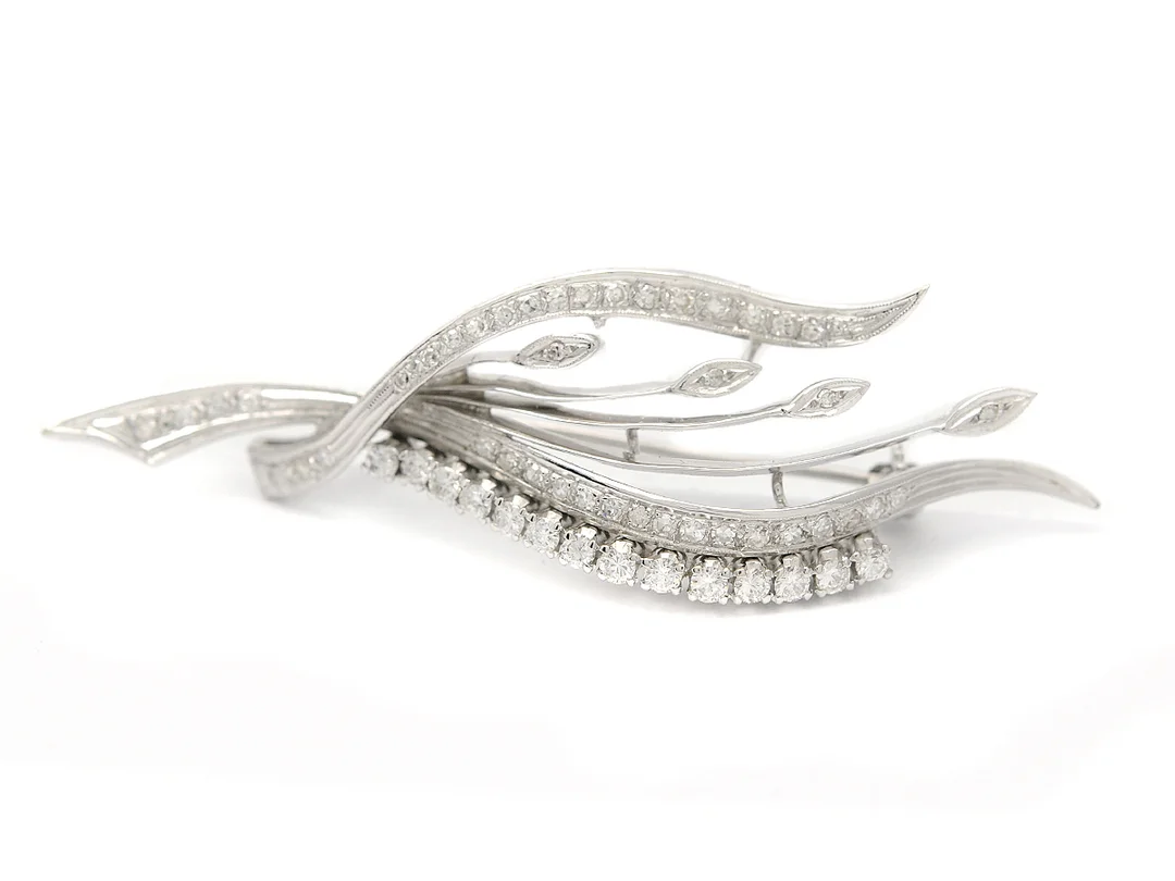 BROSCH, 18K vitguld, 14 briljant- och 43 åttkantslipade diamanter ca 0,90 ctv, ca W-CR/VS-SI, längd 6,3 cm, vikt 7,9 g, tre åttkantslipade och en briljantslipad diamant är skadade. — Smycken/Brosch — Kaplans