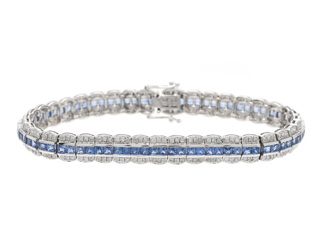 ARMBAND, 8K vitguld, 79 prinsesslipade safirer ca 6,50 ctv, 236 briljantslipade diamanter ca 1,18 ctv, ca TW-Ca/P, längd 18 cm, vikt 15,6 g, svaga fattningar, enstaka safirer har nagg, flera diamanter har skador och nagg. — Smycken/Armband — Kaplans
