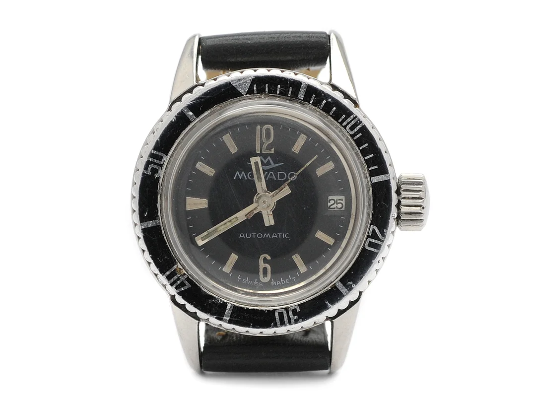 MOVADO, damur, 26 mm, Boett nr. 7152, stål, automatisk, plexiglas, datum, skadad urtavla, skadad boett, läderband, ca 1969. — Klockor/Movado — Kaplans