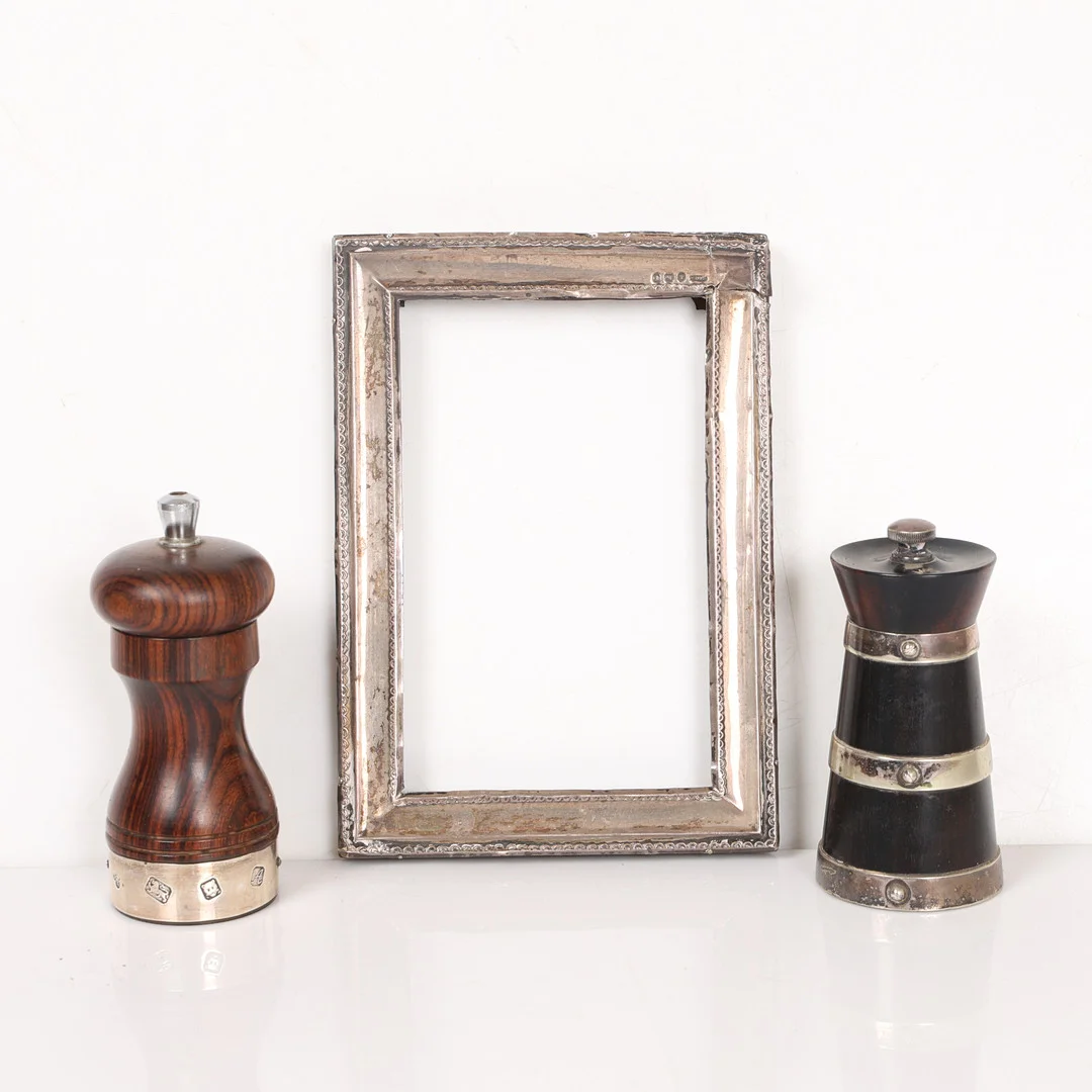 A SILVER MOUNTED PEPPERMILL, A SILVER PHOTO FRAME AND ONE OTHER PEPPERMILL (3). — Silver — Bishop & Miller