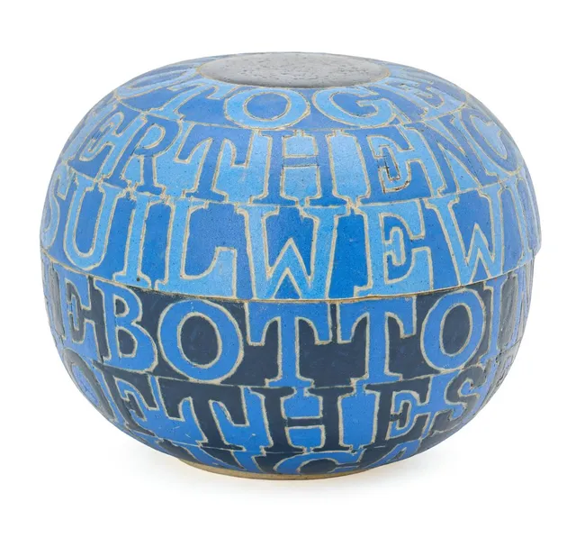 A round stoneware lid jar with incised letters. Decorated with resp. matte and glossy blue glazes. Unsigned. Unique. H. 11 cm. Diam. 14.2 cm.