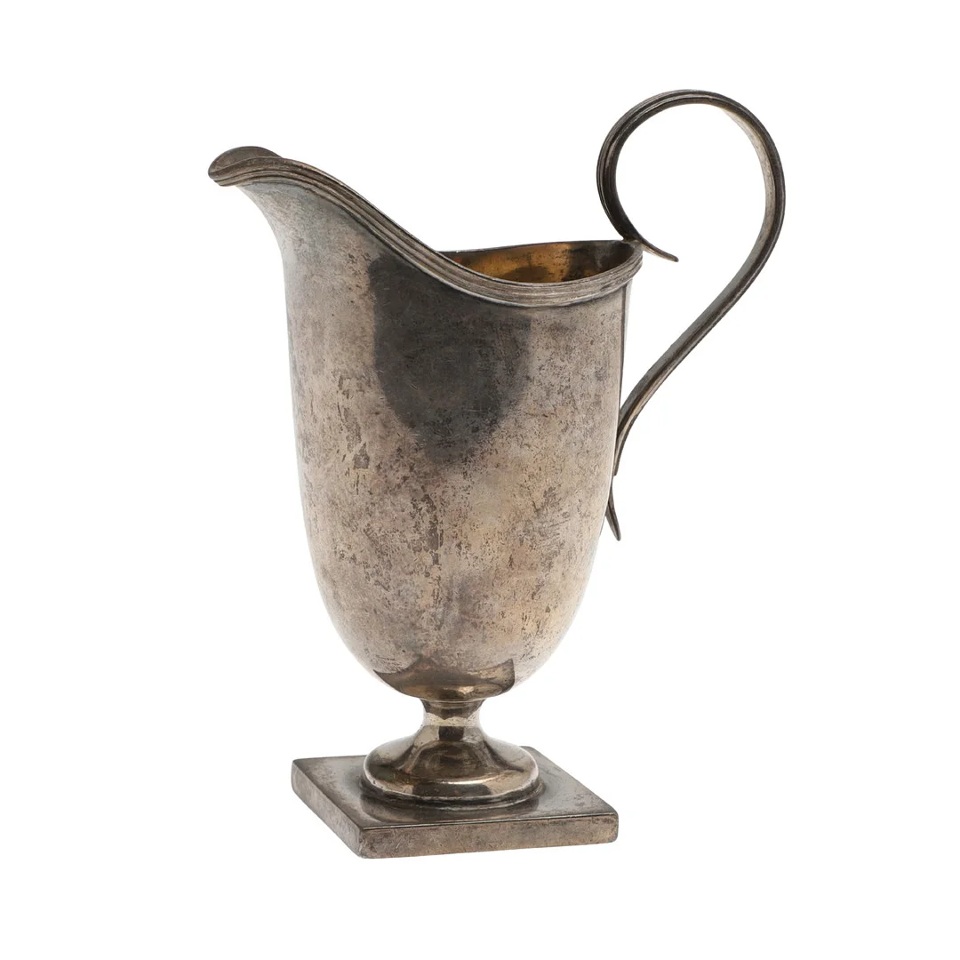 AN EDWARDIAN SILVER HELMET SHAPED CREAM JUG. — Silver — Lawrences Auctioneers
