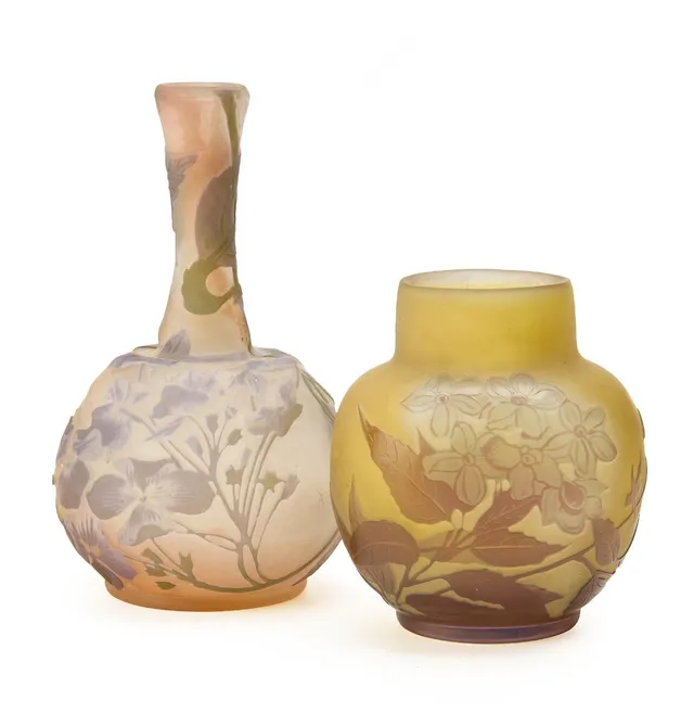 Two vases of resp. yellow and rose glass, overlaid with resp. violet, and lilac and green glass cut with flowers and leaves. Signed Gallé. H. resp. 10 and 14 cm. (2)