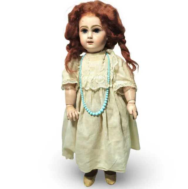 Antigua muñeca articulada con cabeza de porcelana y cartón piedra.