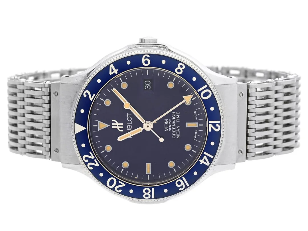 HUBLOT, Geneve, MDM, Greenwich Mean Time, Serie nr. 254456, Boett nr. 1572.1, herrur, 36 mm, stål, quartz, safirglas, datum, 24-timmarsvisning, integrerad originallänk, viklås, ca 1995. — Klockor/Hublot — Kaplans
