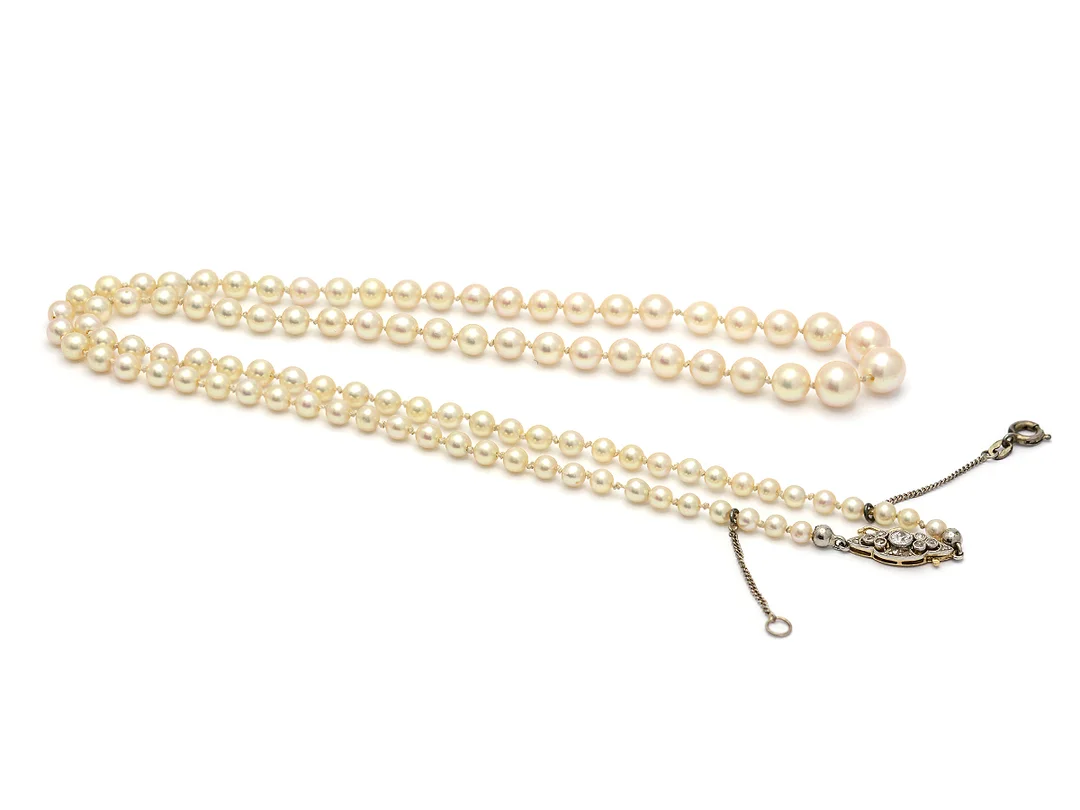PÄRLCOLLIER, odlade pärlor, doserade, ca 3 - 7 mm, lås i 18K guld/platina, diamanter, längd 56 cm, säkerhetskedja, i behov av omträdning. — Smycken/Pärlcollier — Kaplans