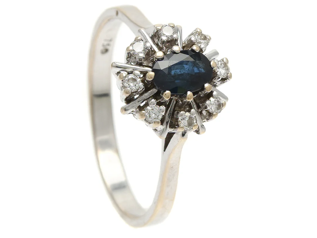 CARMOSÈRING, 18K vitguld, blå safir, 8 briljantslipade diamanter ca 0,16 ctv, ca W-Cr(H-J)/SI, stl 19,5 mm, vikt 4,2 g, mindre nagg på safiren. — Smycken/Carmoséring — Kaplans