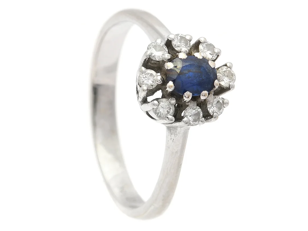 CARMOSÉRING, 18K vitguld, ovalslipad safir ca 0,35 ct, 8 briljantslipade diamanter ca 0,25 ctv, stl 18 mm, vikt 3,7 g, safiren har nagg, slitna klor. — Smycken/Carmoséring — Kaplans