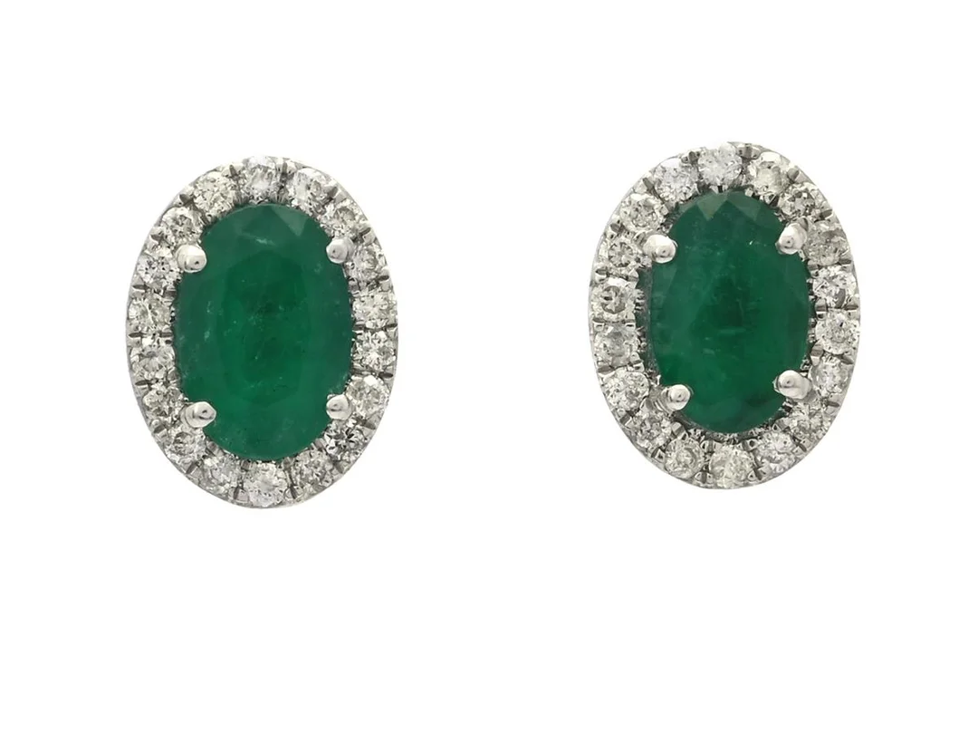 ÖRHÄNGEN, 18K vitguld, 2 ovalslipade smaragder ca 0,95 ctv, 36 briljantslipade diamanter ca 0,18 ctv, ca TW-Cr/P, höjd 8 mm, stift, vikt 2,1 g, smaragderna med inneslutningar som når ytan samt sprickbildningar. — Smycken/Örhängen — Kaplans