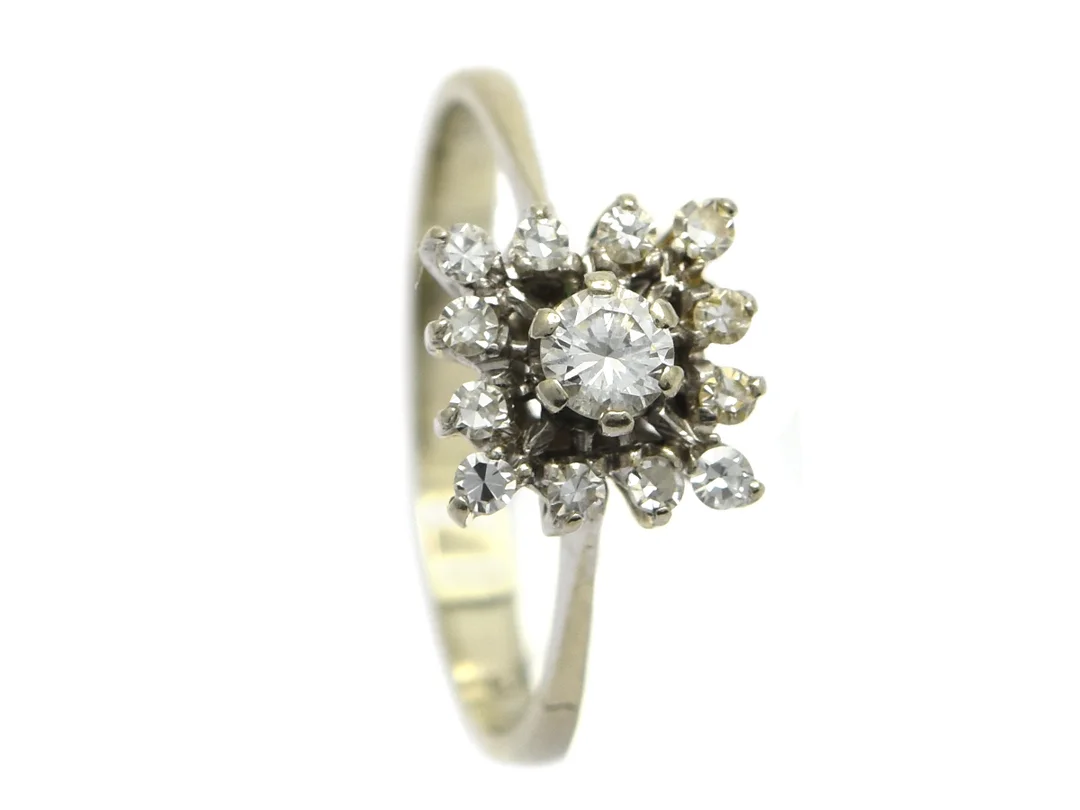 RING, 18K vitguld, briljant ca 0,17 ct, 12 åttkantslipade diamanter ca 0,15 ctv, ca W/VS (mittstenen SI), 1 nagg på en åttkant, stl 16,75+ mm, vikt 2,5 g. — Smycken/Ring — Kaplans