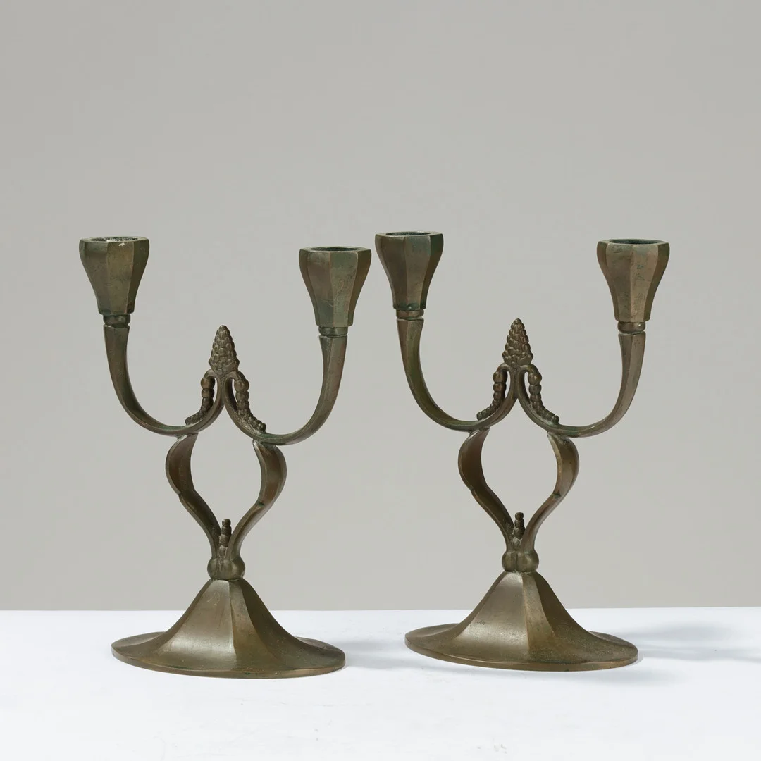 Et par to-armet og ornamenterede lysestager af patineret bronze, Danmark, 1930/40'erne, (2). — Candlesticks — Palsgaard Kunstauktioner