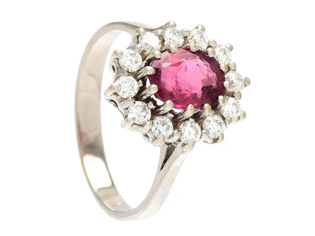 CARMOSÉRING, 18K vitguld, ovalslipad rubin ca 1,64 ct, 12 briljantslipade diamanter ca 0,60 ctv, ca TW/VS, stl 17,75 mm, vikt 4,9 g.
