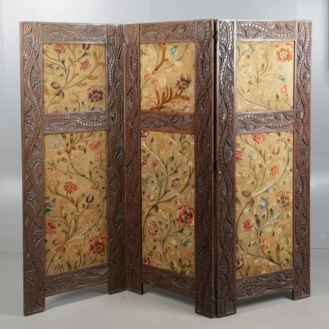 AN EARLY 20TH CENTURY CARVED OAK AND NEEDLEWORK THREE FOLD SCREEN.