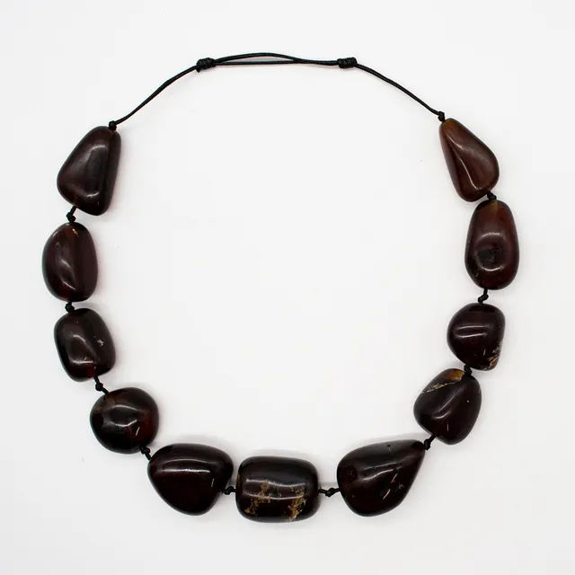 COLLIER AUS GROSSEN BLAUEN BERNSTEINEN MIT NATÜRLICHEN EINSCHLÜSSEN, UNREGELMÄSSIG GEFORMT MIT POLIERTE OBERFLÄCHE, EINZELN GEKNÜPFT AN EINEM SCHWARZEN BAND, ENDLOSKETTE, VERSTELLBAR.