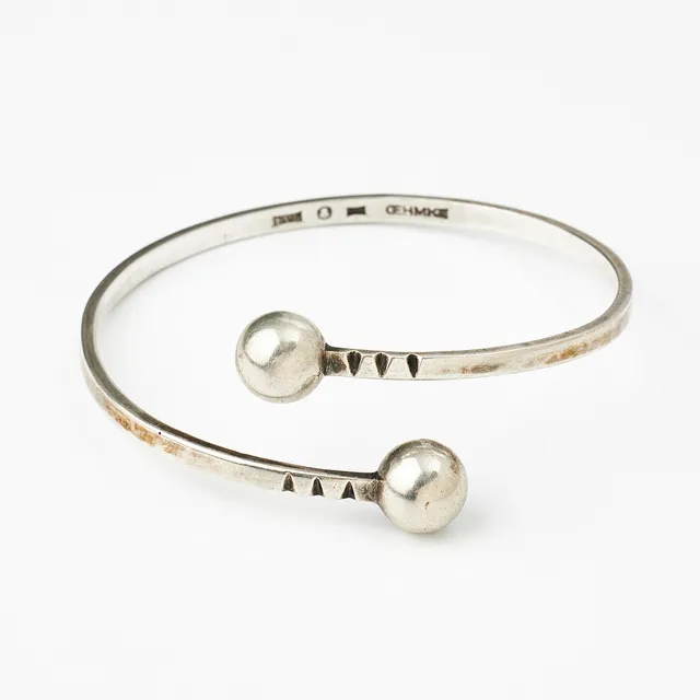 ARMRING, silver, öppen skena med kulformade avslut, hamrad dekor, Silversmed Lennart Oehmke, Stockholm 1965.