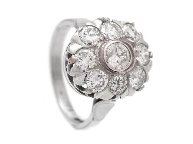 CARMOSÉRING, 18K vitguld, 9 briljantslipade diamanter 2,08 ct, ca TW-W/P1, Stockholm 1966, stl 17 mm, vikt 5 g, mittstenen med skada på kronan och inneslutning som når ytan.